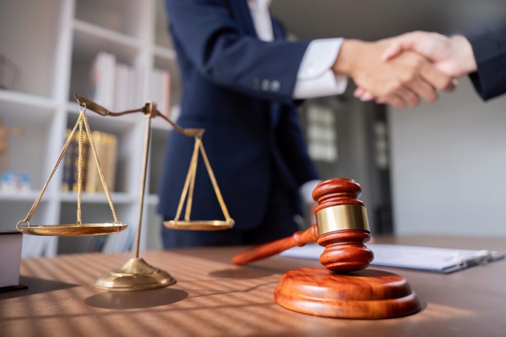 professional,lawyer,handshake,in,business,meeting,with,scales,of,justice